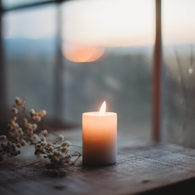 Kerze im warmen Licht am Fenster – Moment der Ruhe und Dankbarkeit